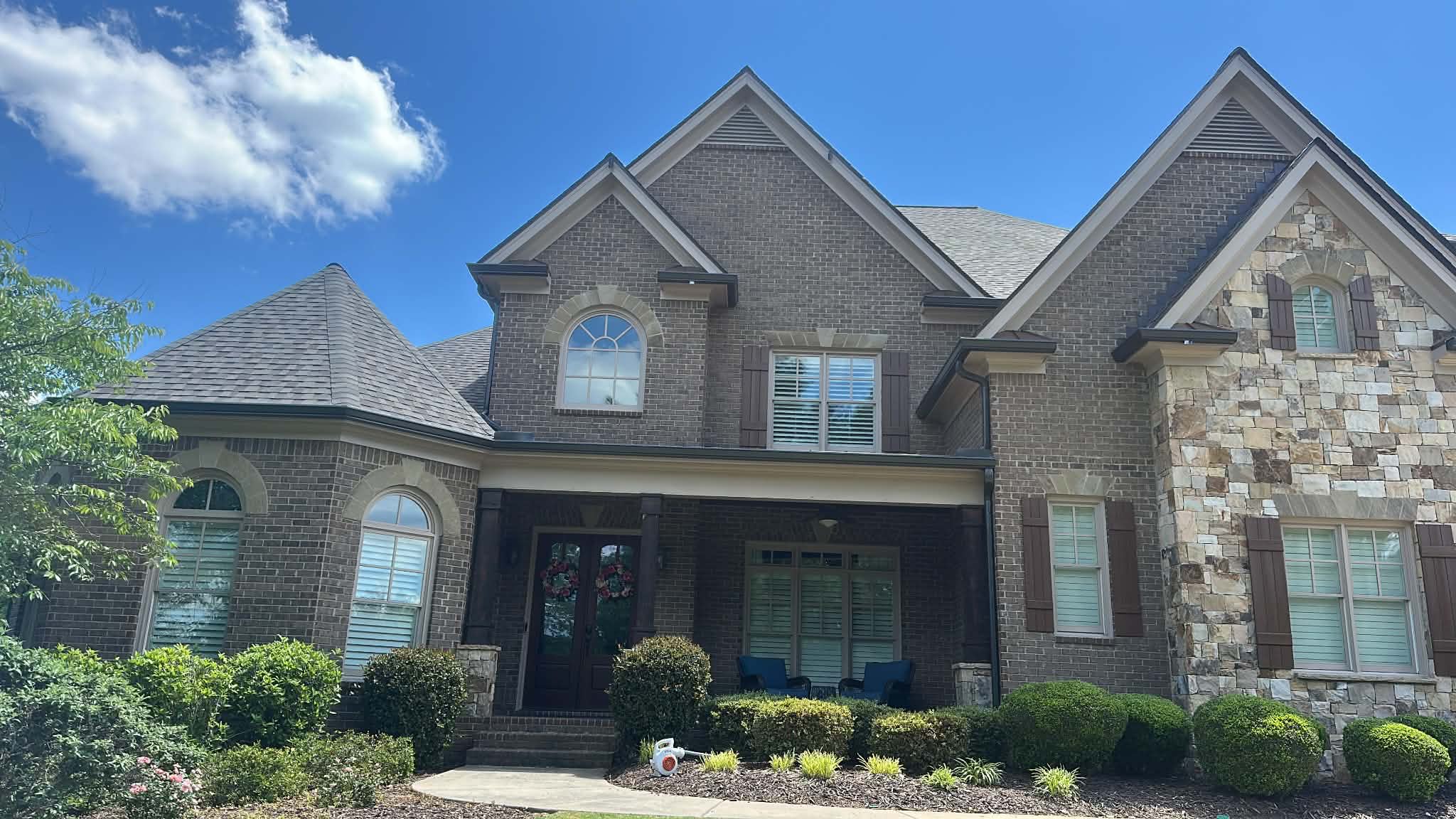 Front of a brick home with a completed roof
